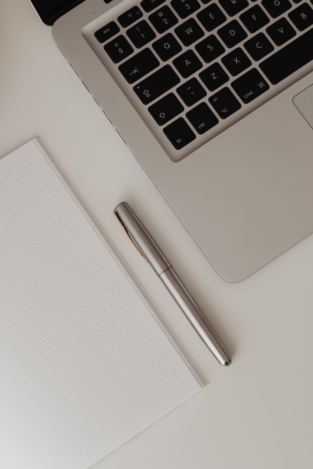 Laptop, notepad and pen on a desk